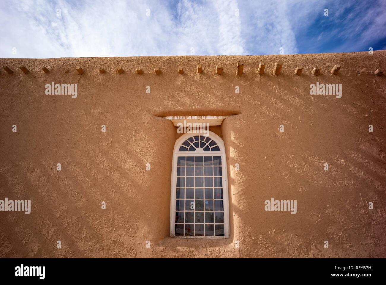 Shadows on a wall and window of San Francisco de Asis adobe church in Ranchos de Taos, New Mexico, USA Stock Photo
