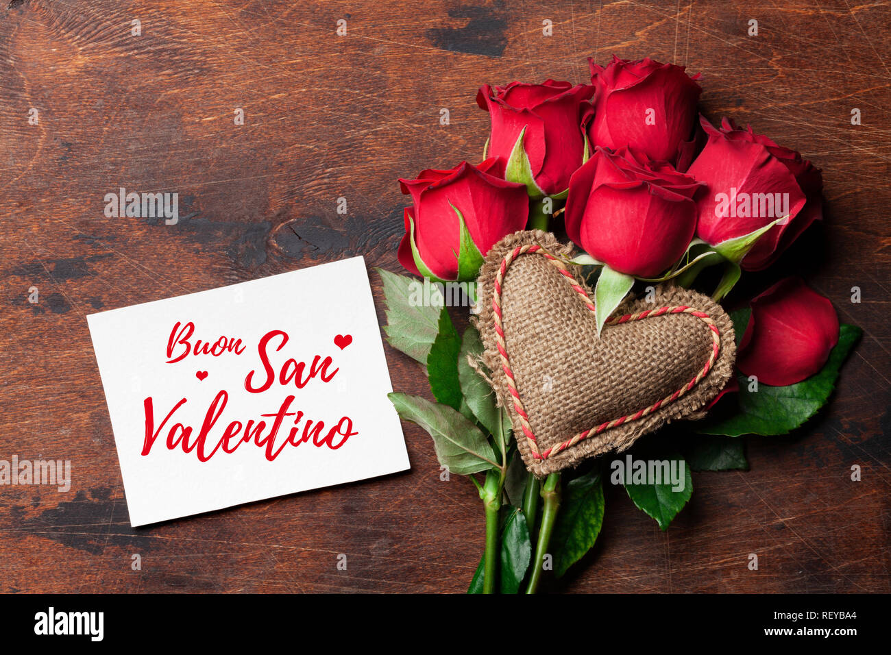 Valentine's day greeting card with red rose flowers bouquet and knitted  heart on wooden background. Boun San Valentino Italy. Top view with space  for Stock Photo - Alamy