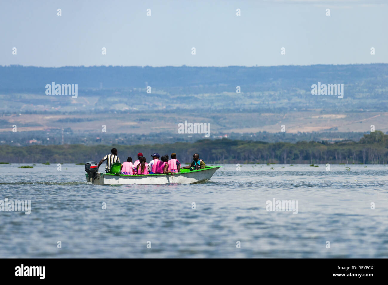 A group of African men and women taking an excursion in a fibreglass motorboat on Lake Naivasha, Kenya Stock Photo