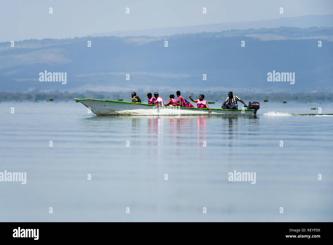 A group of African men and women taking an excursion in a fibreglass motorboat on Lake Naivasha, Kenya Stock Photo