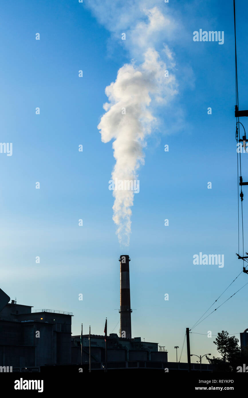 A smoke stack discharging smoke or steam in south Seattle, Washington