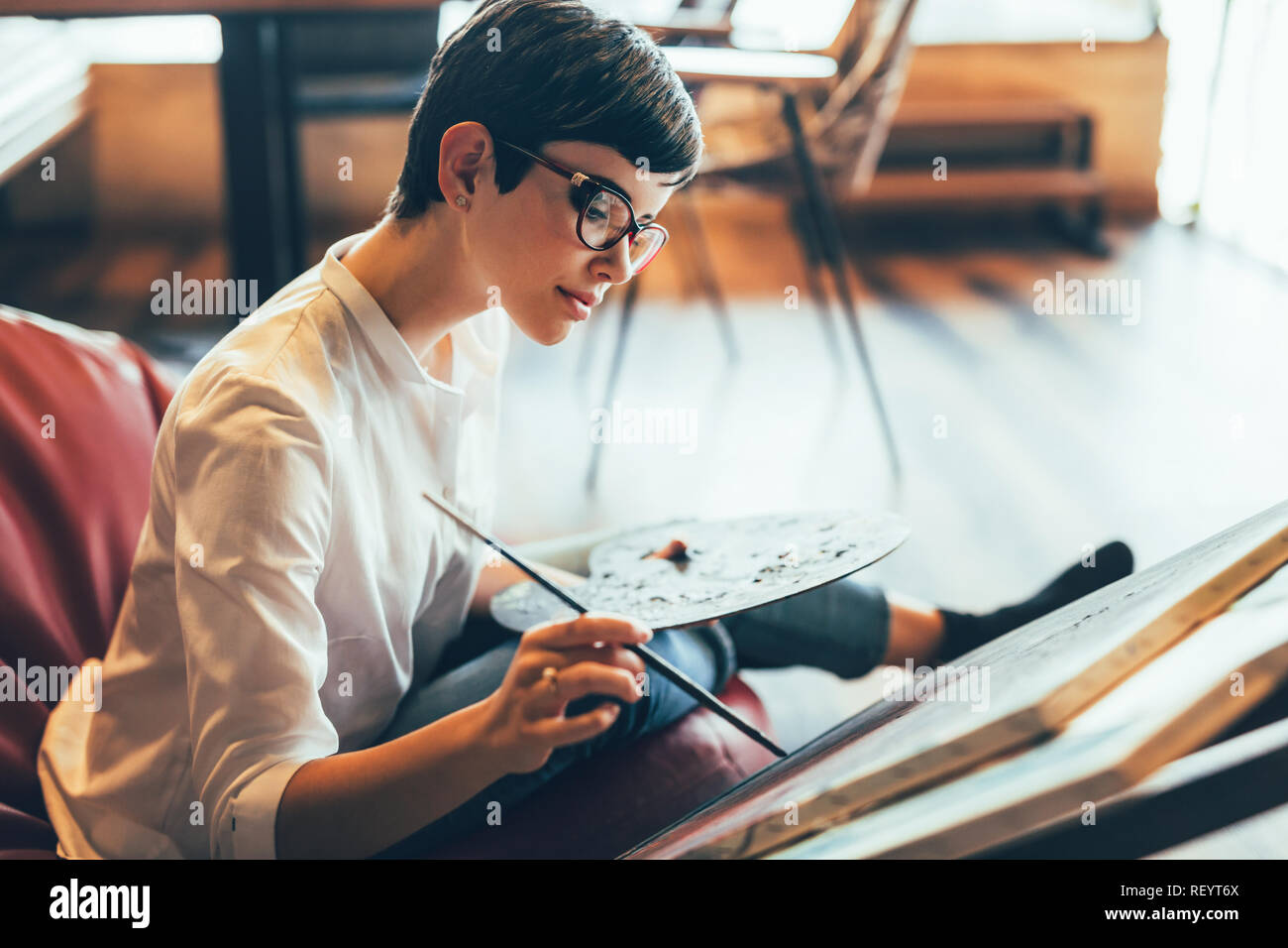 Beautiful young woman attending a painting workshop Stock Photo