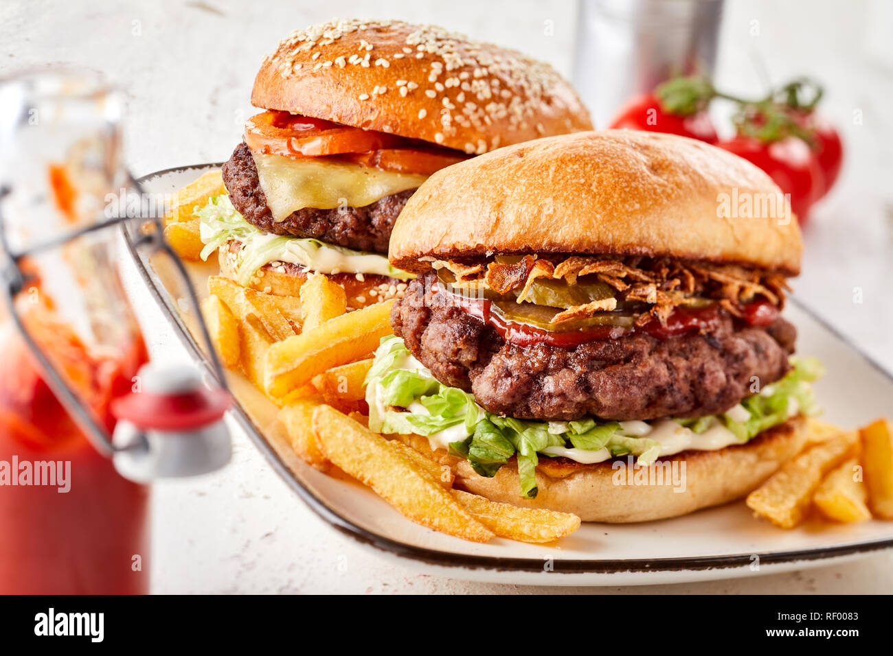 Two assorted burgers on crusty toasted buns with all the trimmings