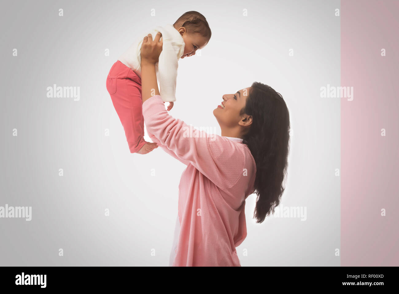 Smiling Mother lifting baby Stock Photo Alamy