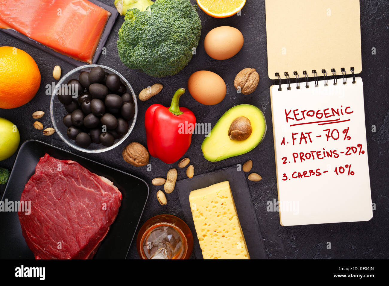 Photo of products for diet, notebook on black stone table. Stock Photo