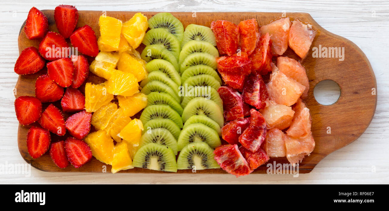 https://c8.alamy.com/comp/RF06E7/chopped-fruits-arranged-on-cutting-board-on-white-wooden-surface-overhead-view-ingredients-for-fruit-salad-from-above-flatlay-RF06E7.jpg