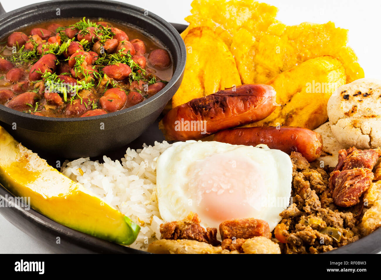 Traditional Colombian dish called Bandeja Paisa: a plate typical of Medellin that includes meat, beans, egg and plantain Stock Photo