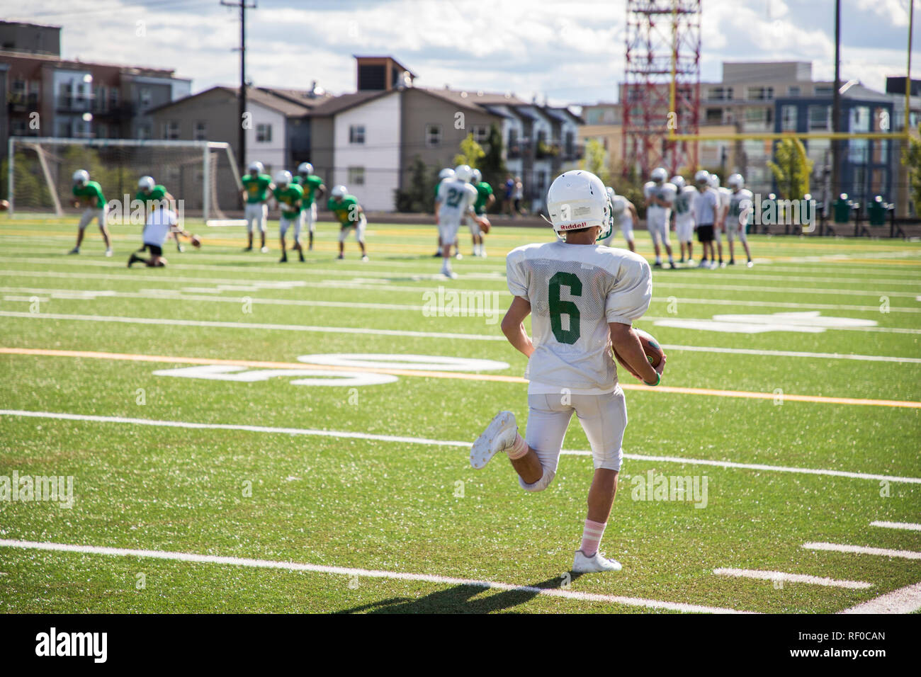 Kid running with football down field Stock Photo Alamy
