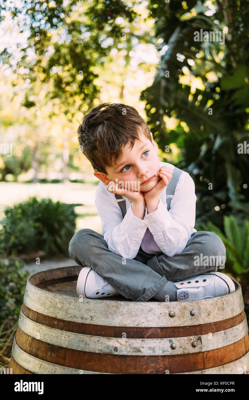 Boy sitting on barrel Stock Photo