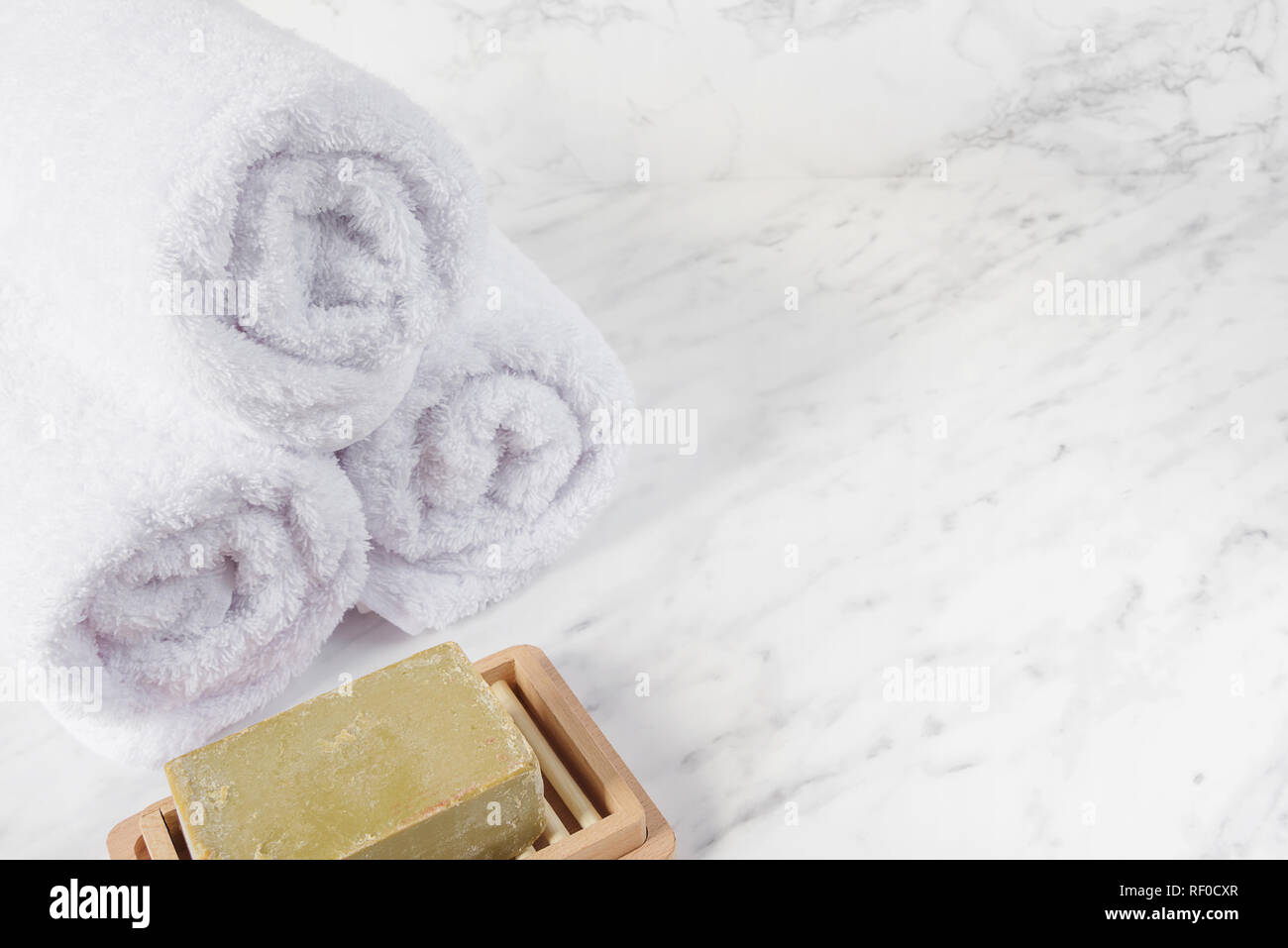 Bar of natural handmade organic soap and white terry towels on a marble background, with space for text Stock Photo