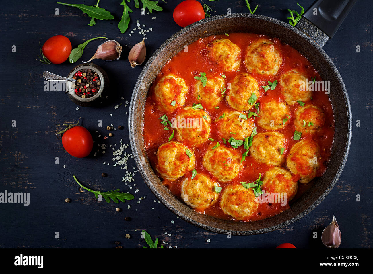 Chicken meatballs with tomato sauce in a pan. Dinner. Top view. Dark background. Stock Photo
