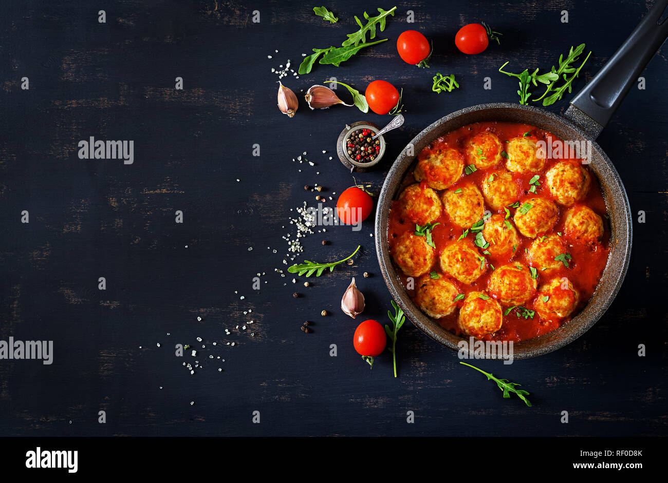 Chicken meatballs with tomato sauce in a pan. Dinner. Top view. Dark background. Stock Photo