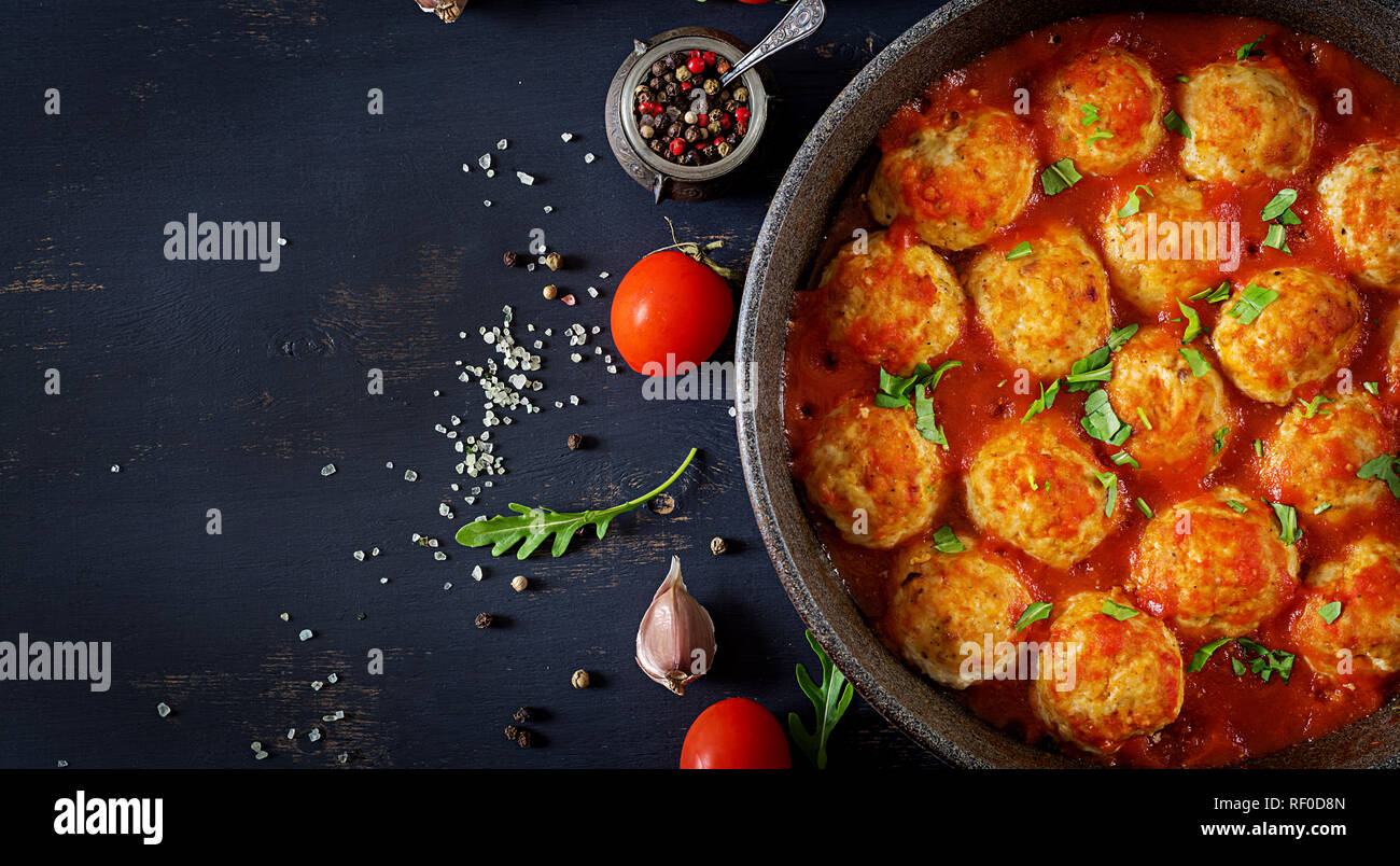 Chicken meatballs with tomato sauce in a pan. Dinner. Top view. Dark background. Stock Photo