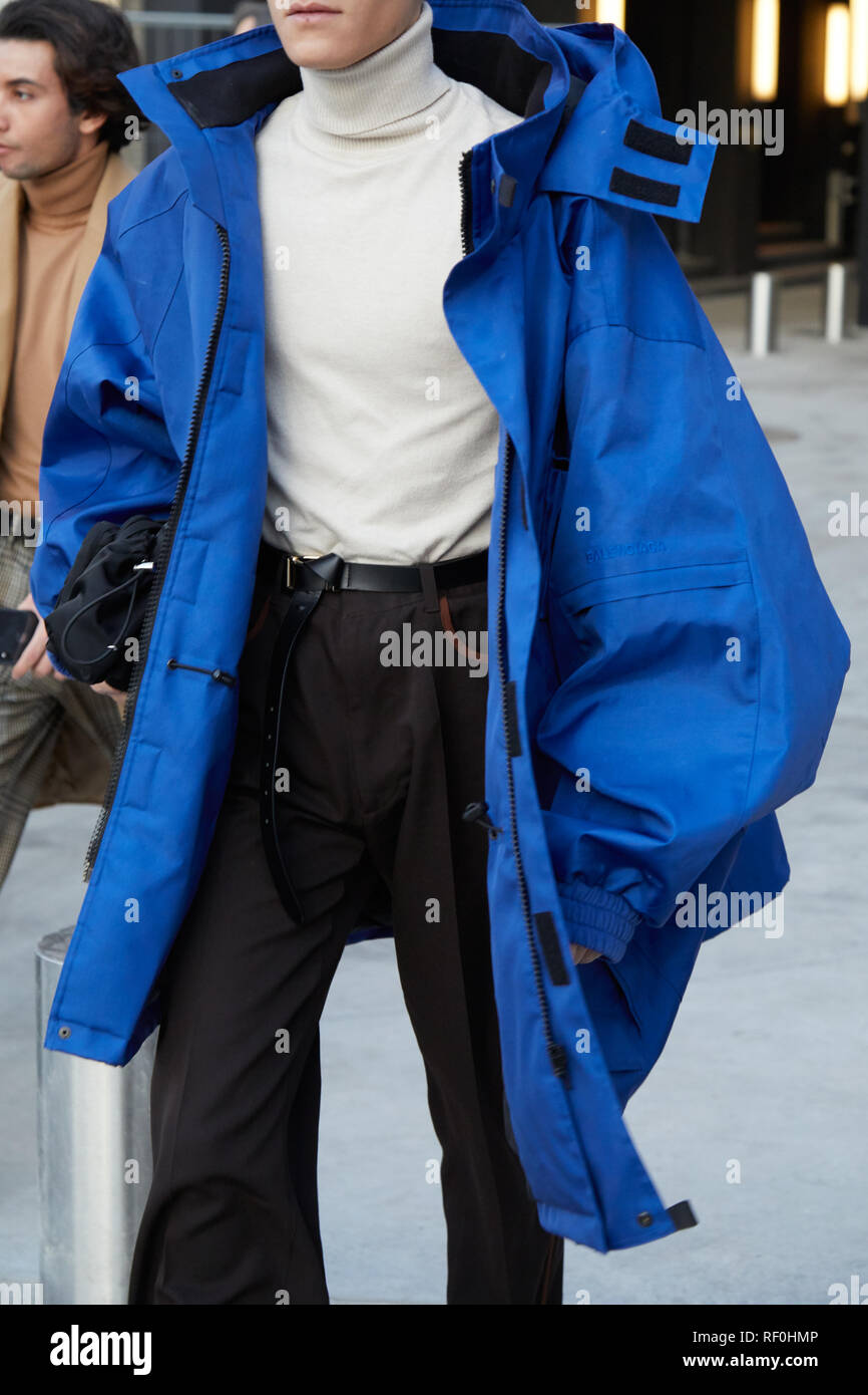 MILAN, ITALY - JANUARY 12, 2019: Man with large, blue jacket and white turtleneck before Neil Barrett fashion show, Milan Fashion Week street style Stock Photo