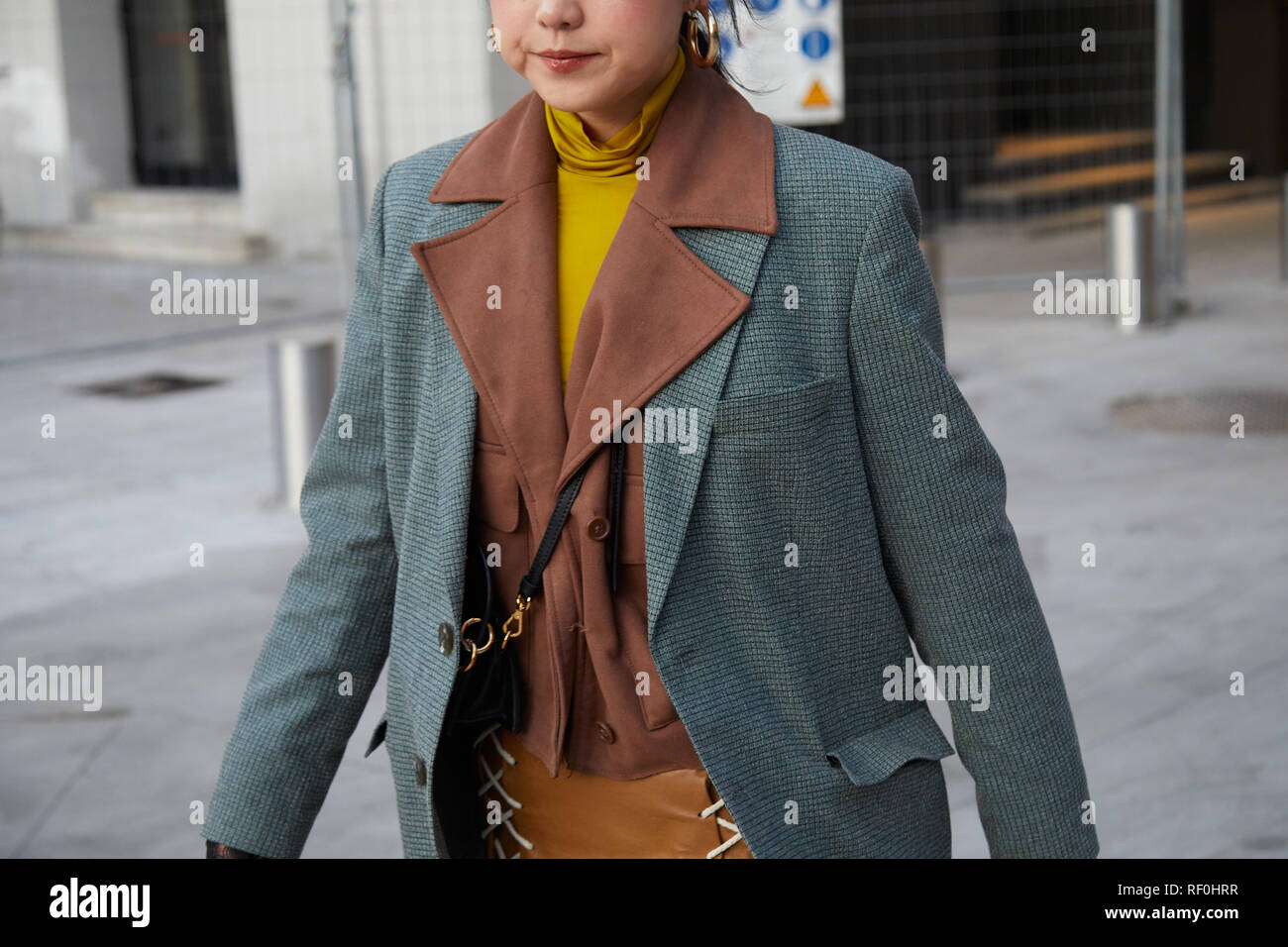 MILAN, ITALY - JANUARY 12, 2019: Woman with brown jacket and yellow turtleneck before Neil Barrett fashion show, Milan Fashion Week street style Stock Photo
