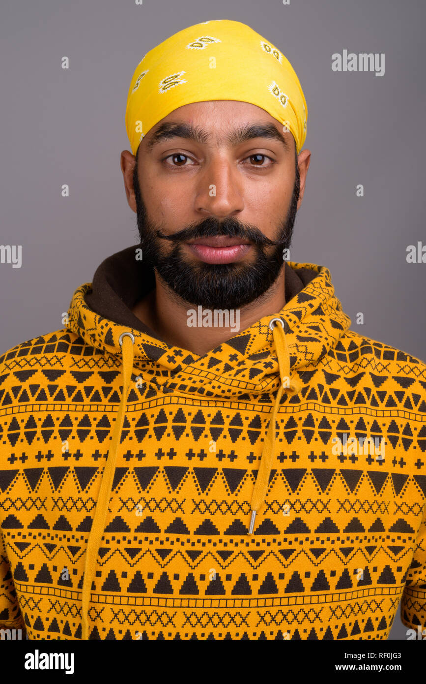 Portrait of young handsome Indian man wearing hoodie Stock Photo