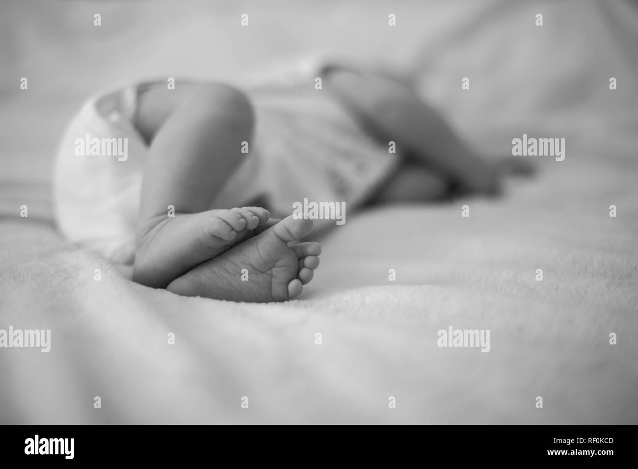 Cute feet of newborn baby sleeping on the bed Stock Photo Alamy