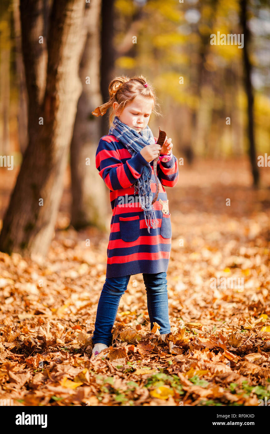 Portrait of little girl in autumn park with yellow foliage Stock Photo ...