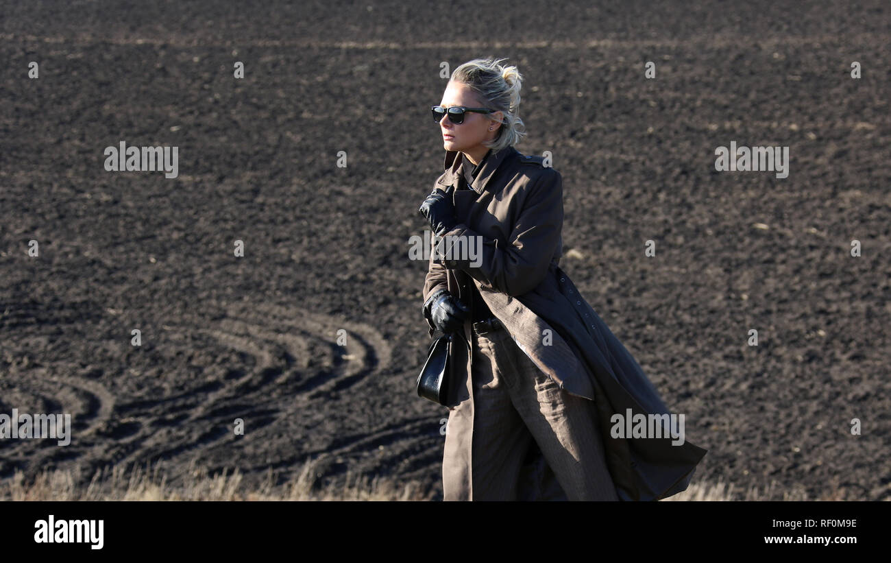 woman in a suit on a hill in a deserted field Stock Photo