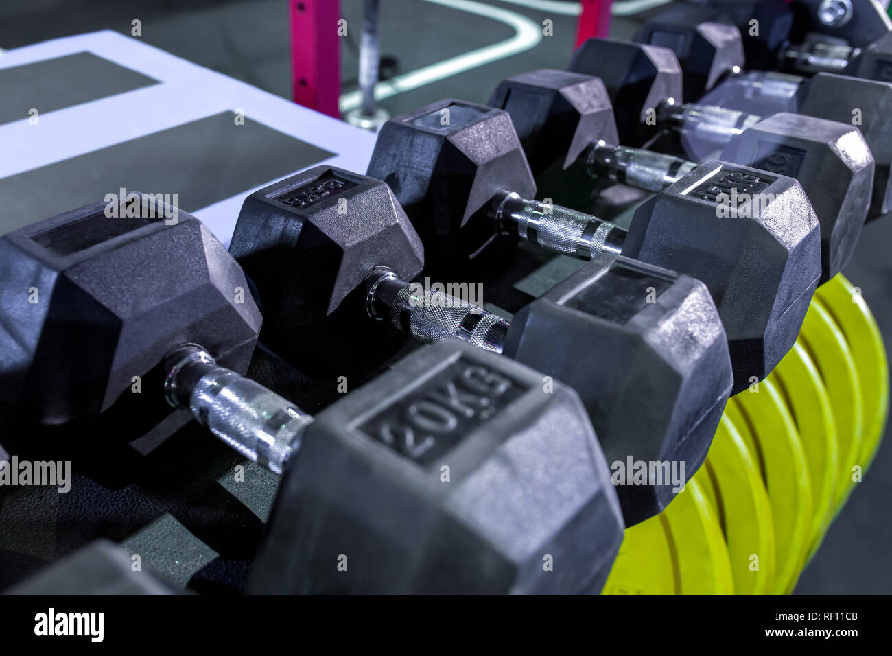 Dumbbells, pancakes and weights lying on the shelves. Gym. Equipment for gym Stock Photo