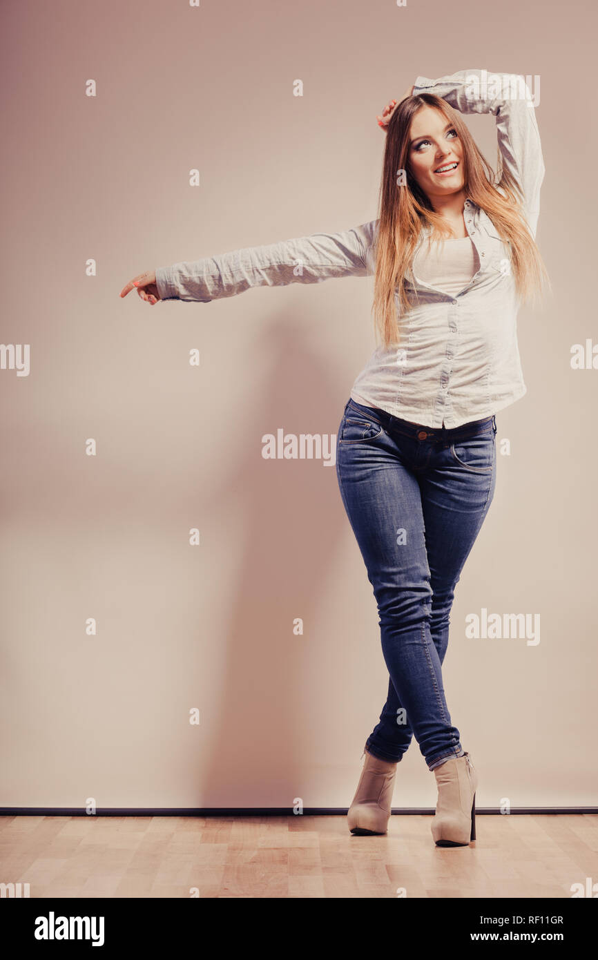 Fashion. Young long hair fashionable woman jeans pants shirt. Female