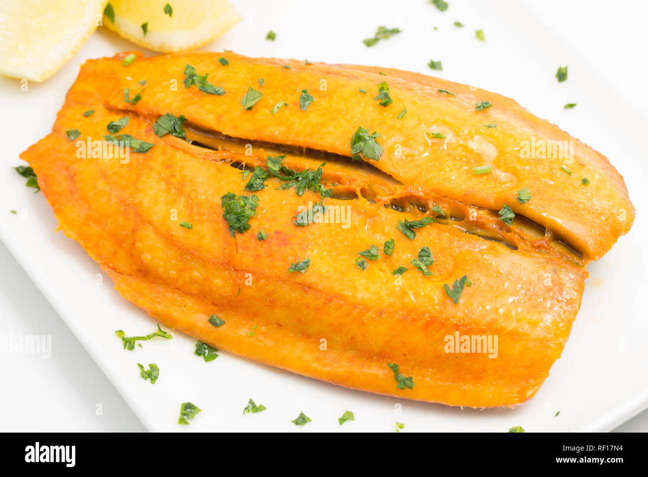 A cooked boil in the bag kipper bought from a supermarket and garnished with fresh parsley. England UK GB Stock Photo