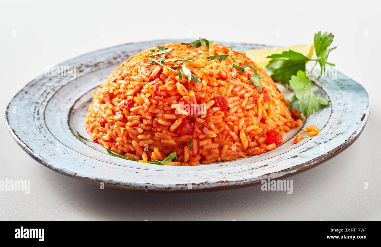 Traditional greek tomato rice, domatoriza or pilaf, and coriander on a