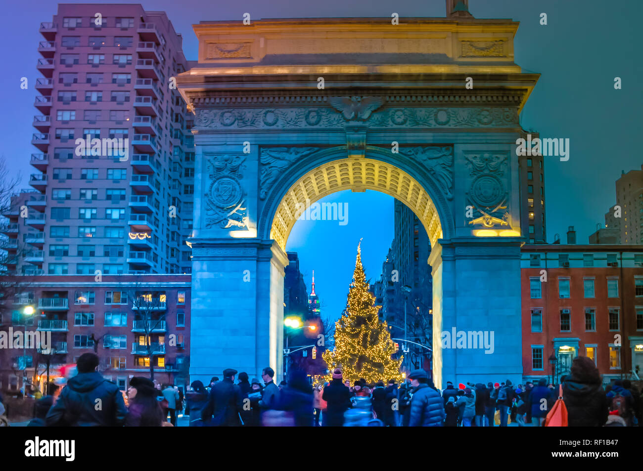 New York City, NY / USA - 12 25 2013: People are walking during Christmas time at Washington Square in Manhattan at night in front of Christmas tree Stock Photo