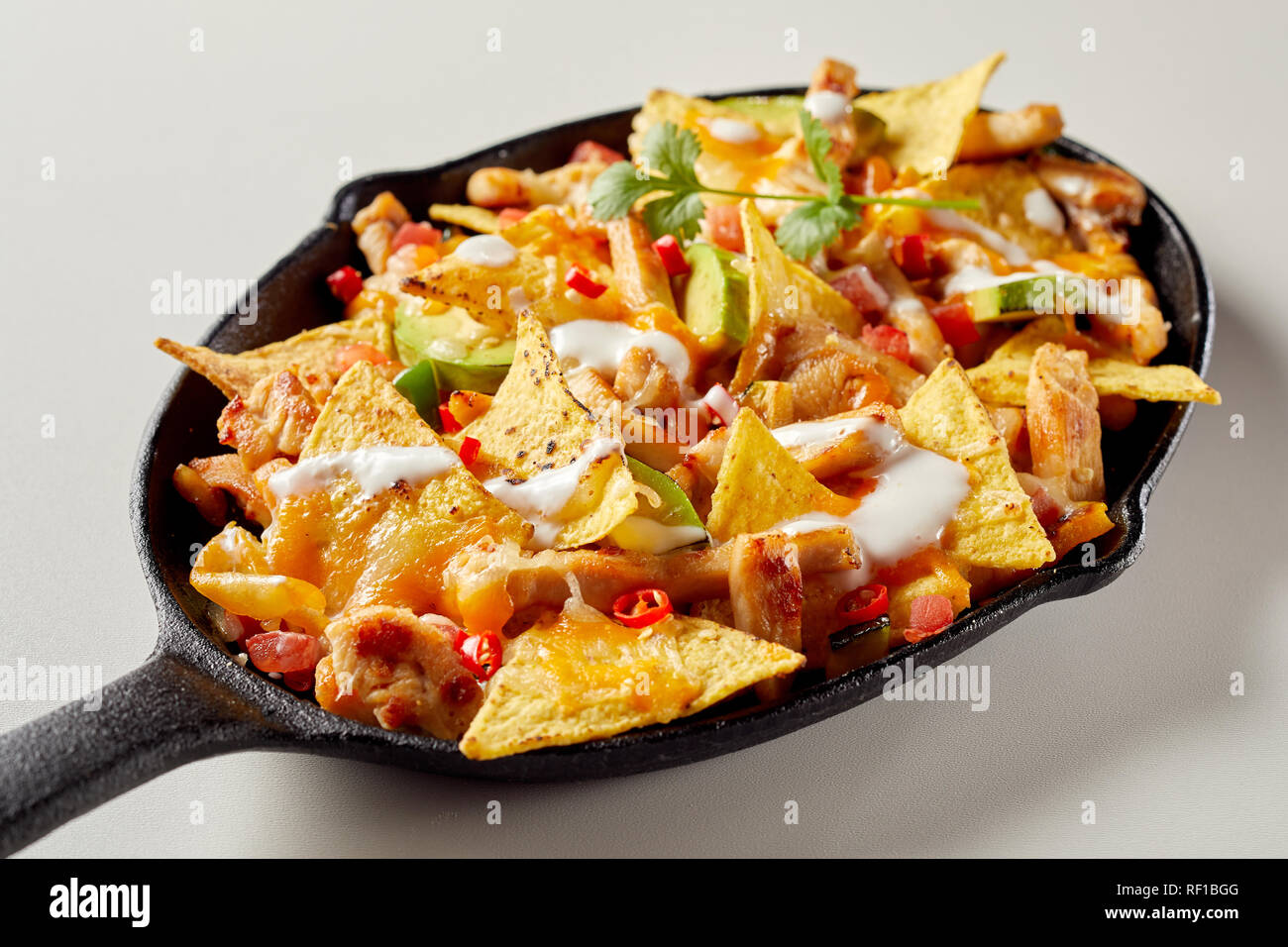 Pan full of chicken nacho tortilla with sauce Stock Photo