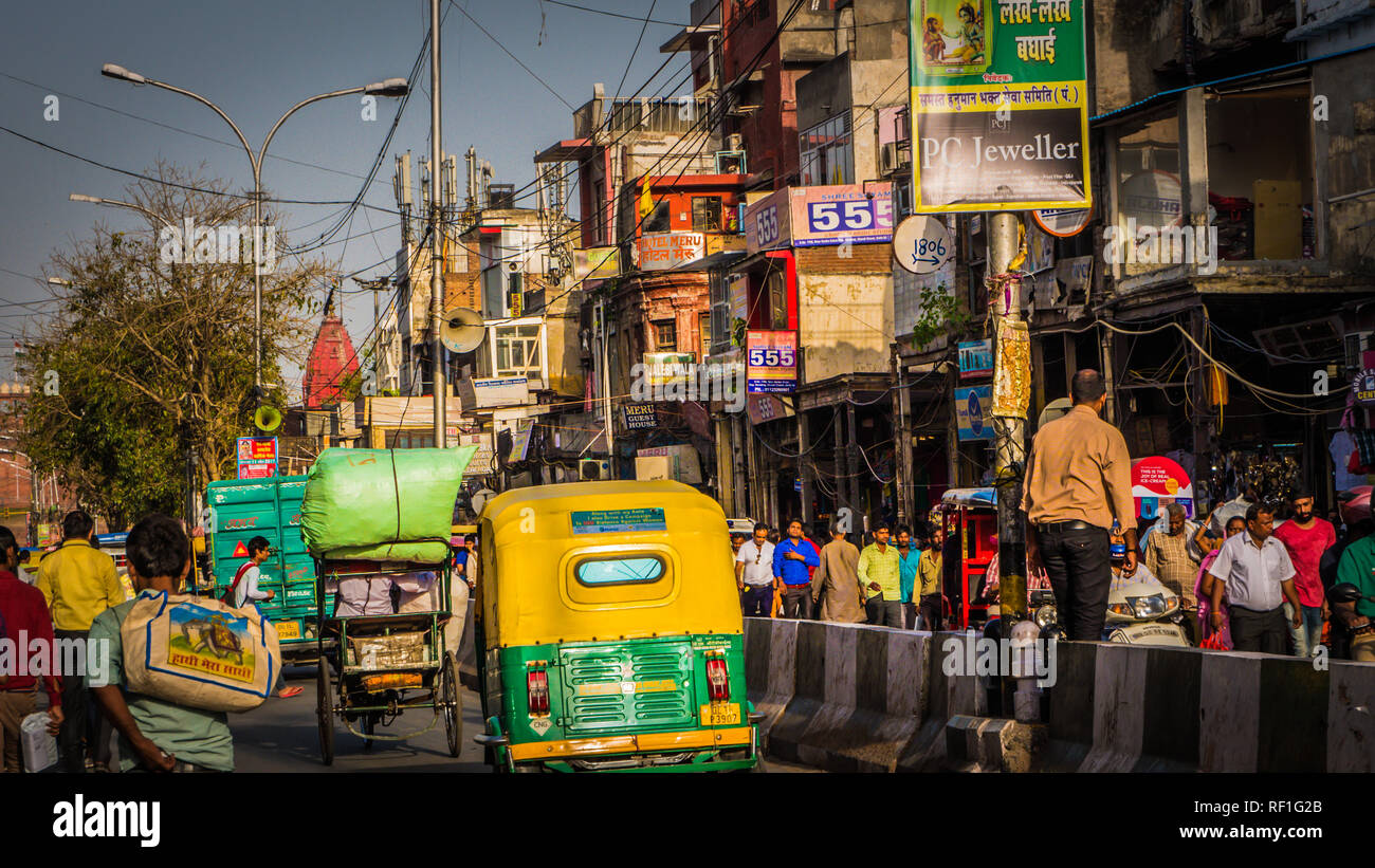 New Delhi / India - April 12 2017: Busy street Chandni Chowk in Old Delhi downtown area with crowds of people, yellow rickshaws. Stock Photo