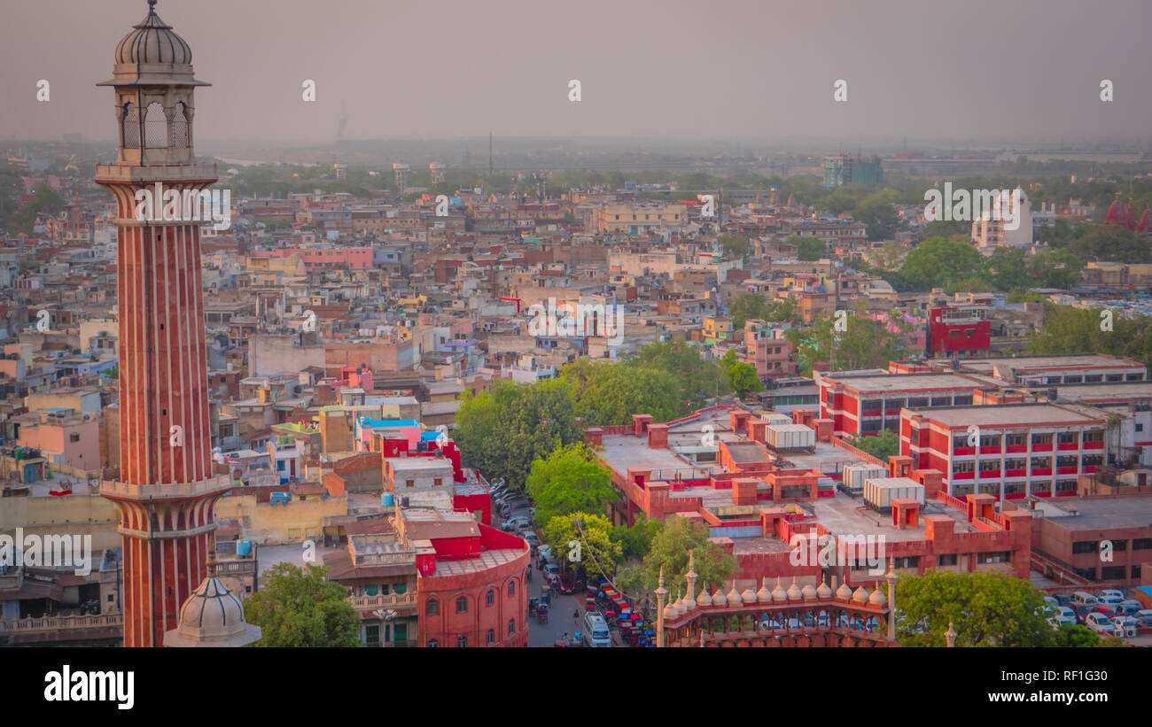 View of old part of New Delhi, busy market bazaar street and the Red Fort from a minaret at Jama Masjid mosque. Stock Photo