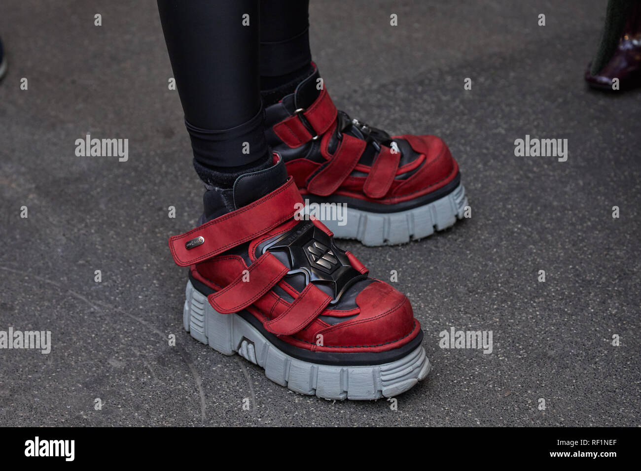 MILAN, ITALY - JANUARY 13, 2019: Woman with New Rock red and gray shoes before John Richmond fashion show, Milan Fashion Week street style Stock Photo