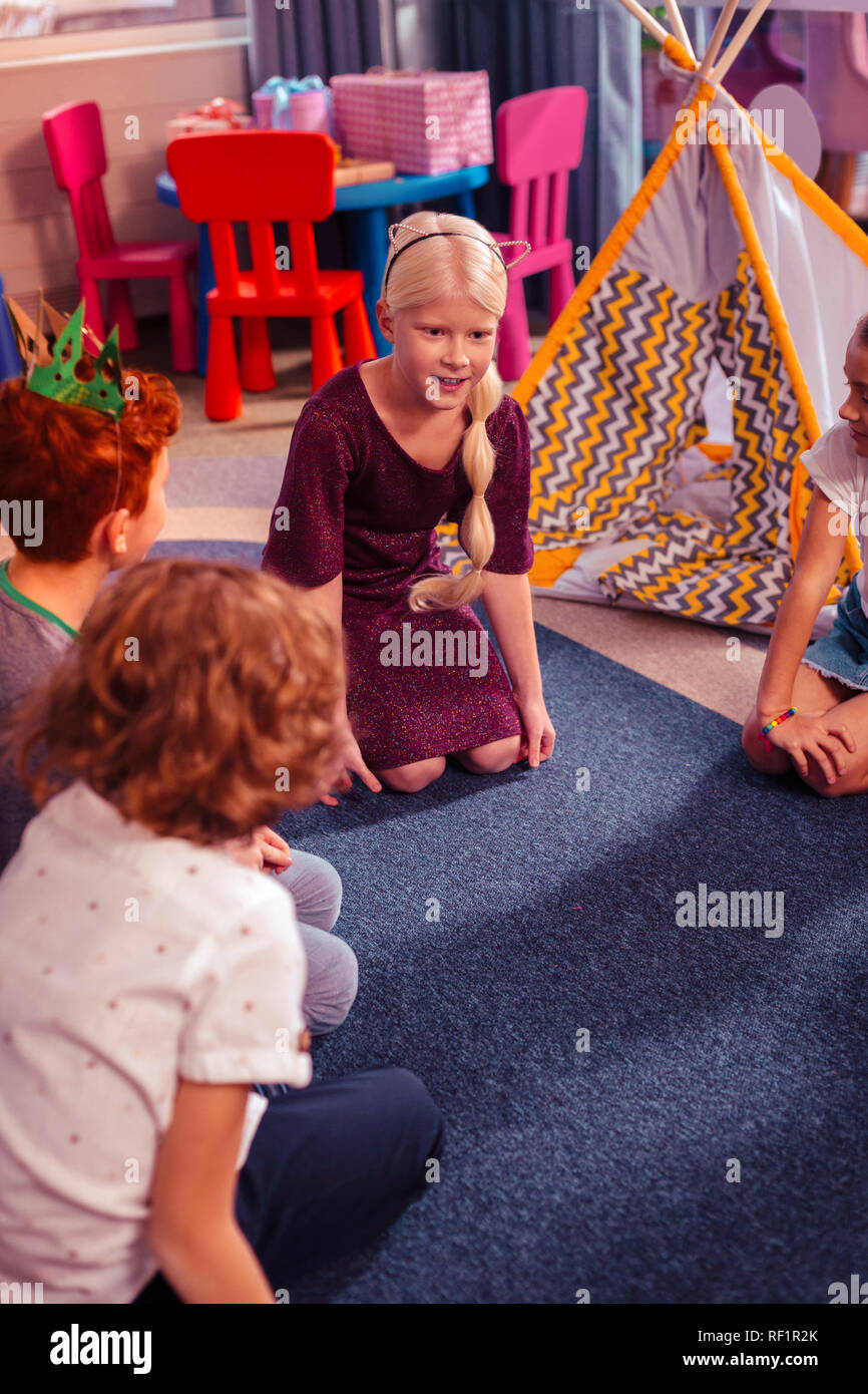 Cheerful blonde little female talking to her classmates Stock Photo - Alamy