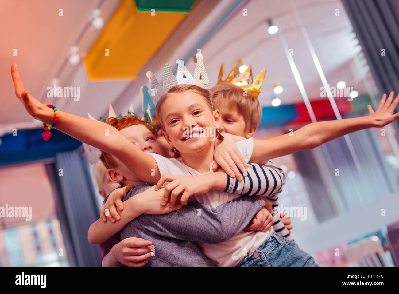 Positive delighted kids lifting happy birthday girl Stock Photo - Alamy