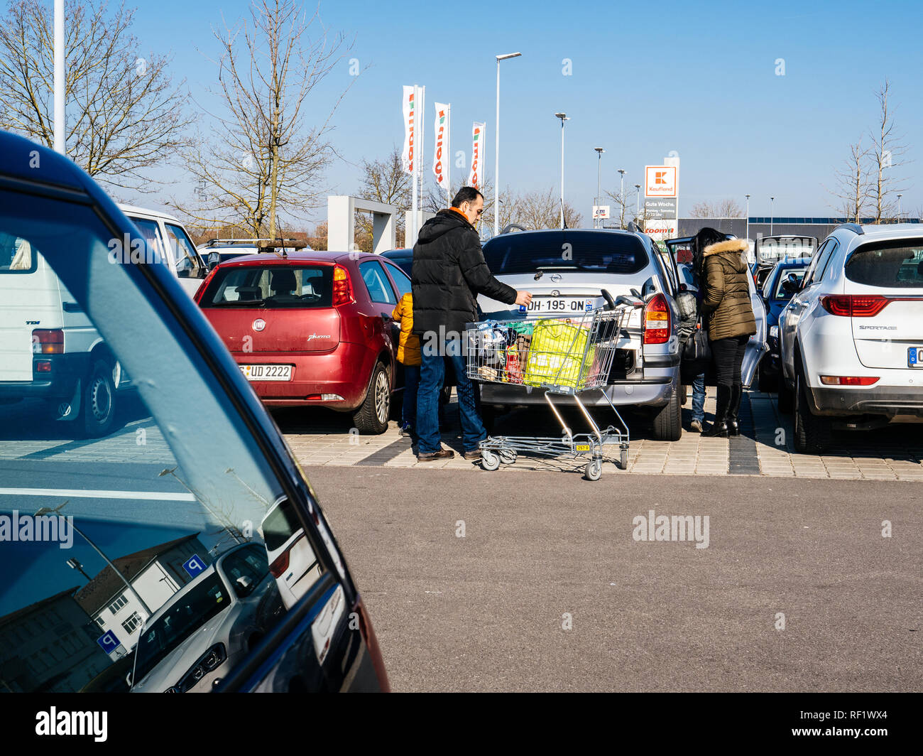 KARLSRUHE, GERMANY - FEB 24, 2018: Middle Eastern ethnicity family couple loading groceries in Kaufland supermarket food parking  Stock Photo