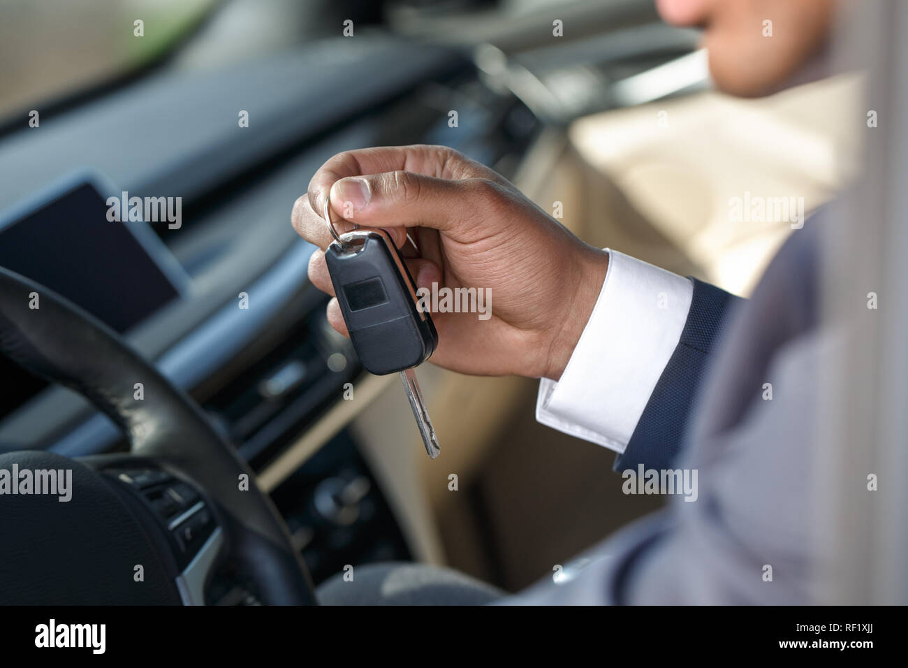 Young man sitting inside car with key cllose-up Stock Photo