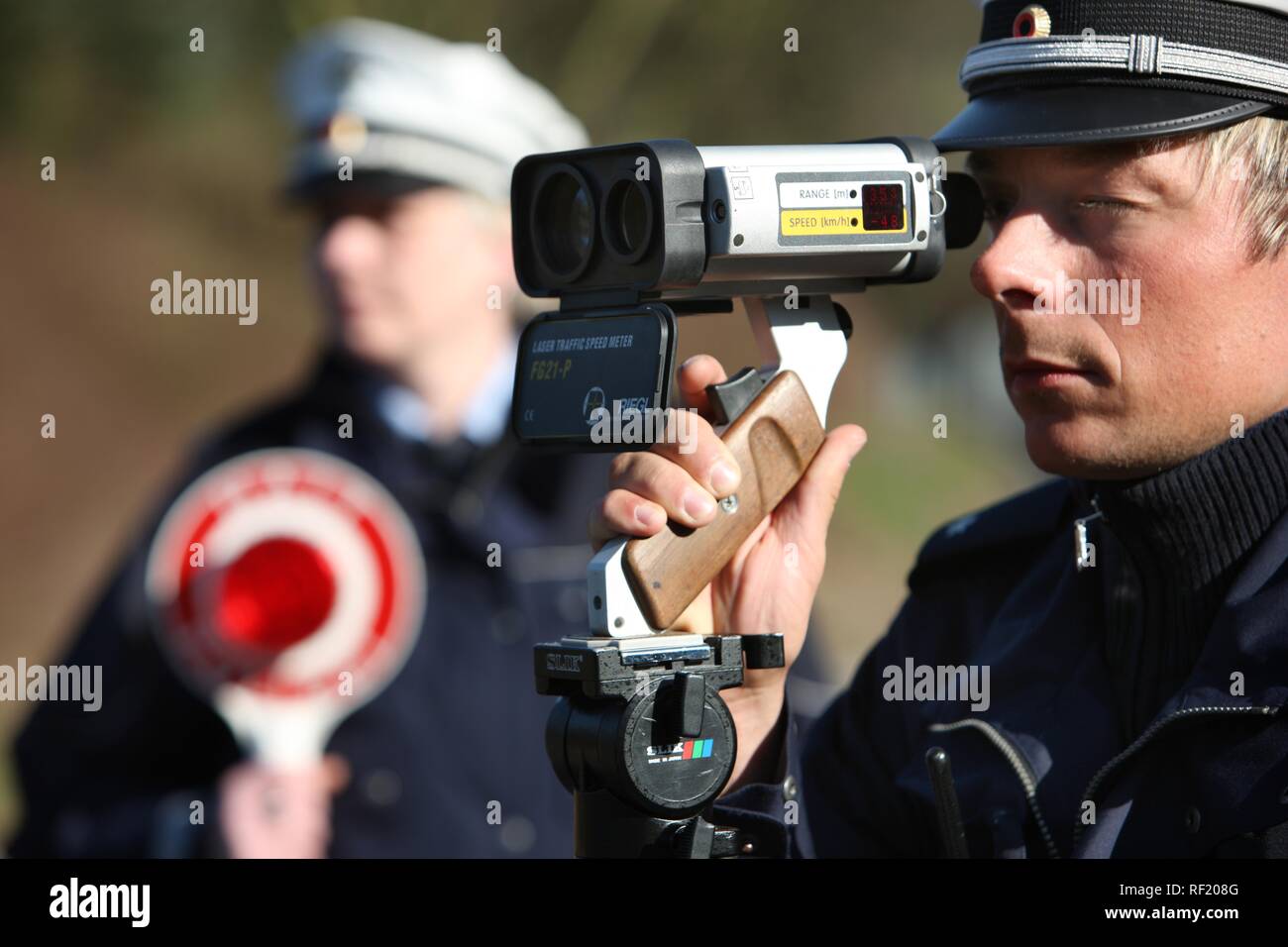 Police officer checking speed with radar gun hires stock photography
