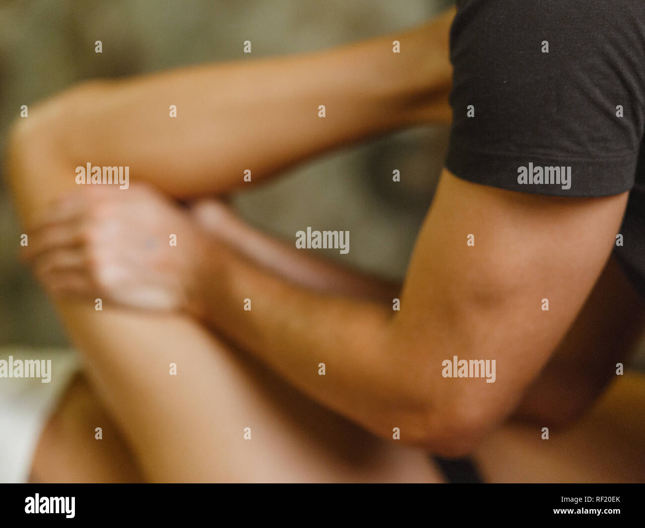 Extreme close up of osteopath applying pressure with thumb on female calf muscle. close up, blur Stock Photo