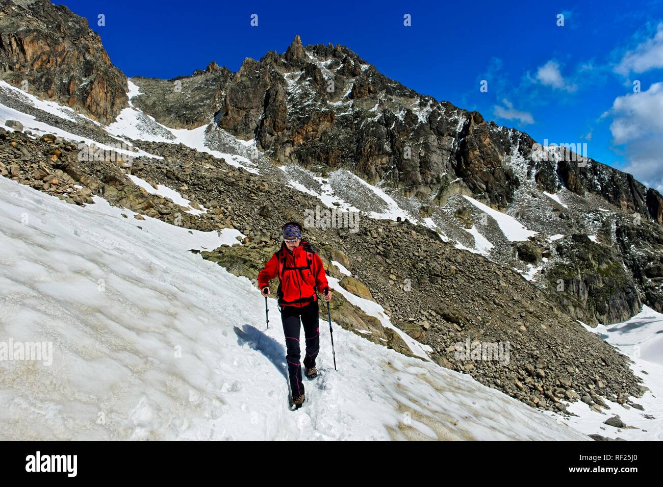 Hiker crosses a snowfield on the way to the Orny Hut, Valais, Switzerland Stock Photo