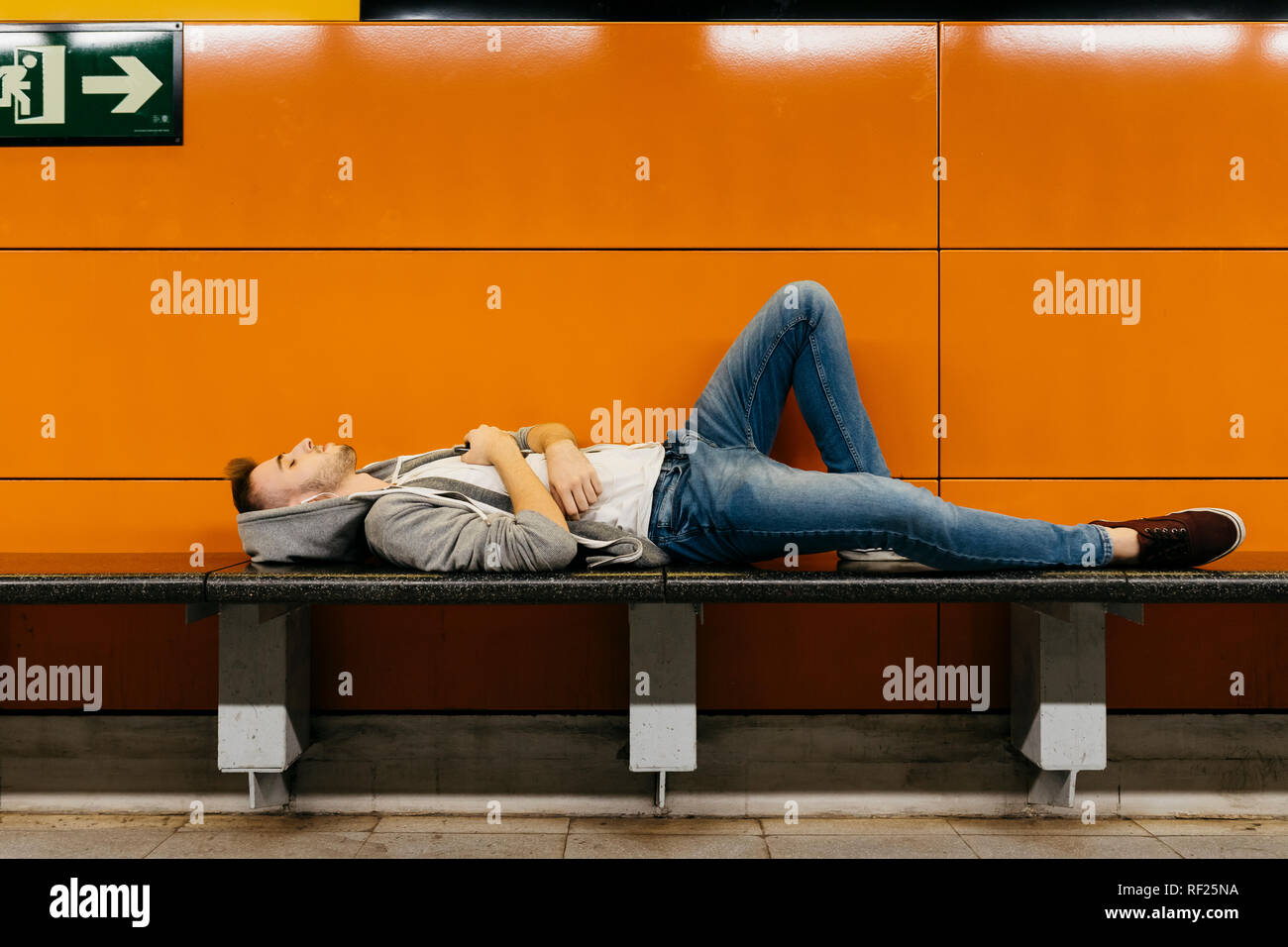 Young man waiting for the metro, resting on bench Stock Photo