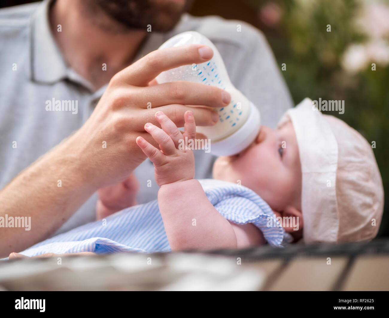 Father bottle-feeding baby girl Stock Photo