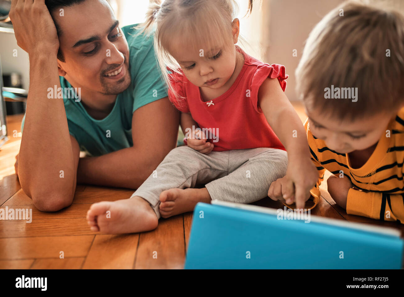 Father and his children using digital tablet at home Stock Photo