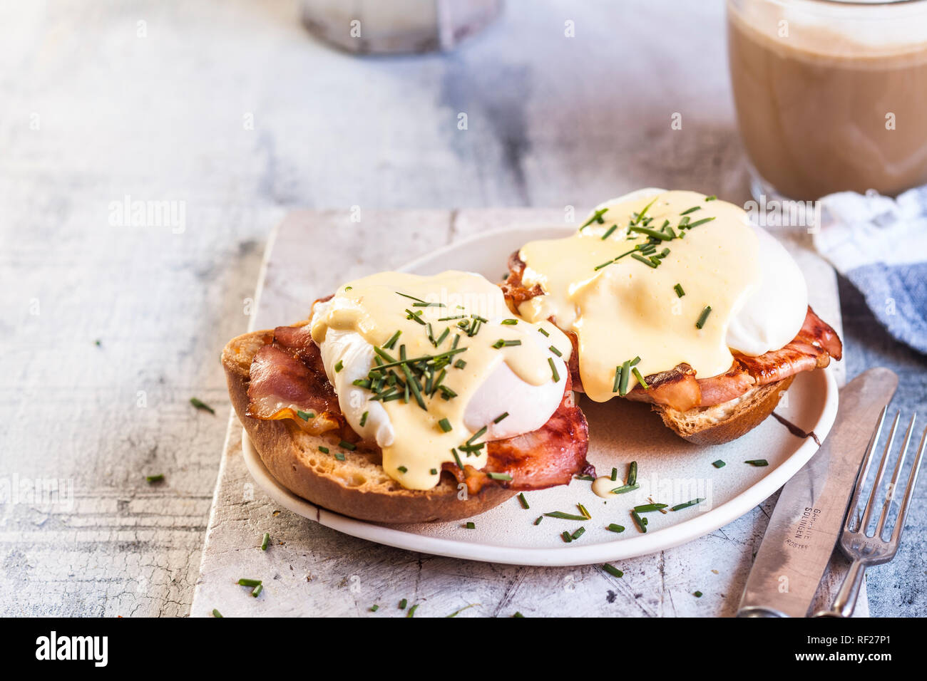 Traditional egg benedict with slices of bacon on toast,  poached egg and hollandaise Stock Photo