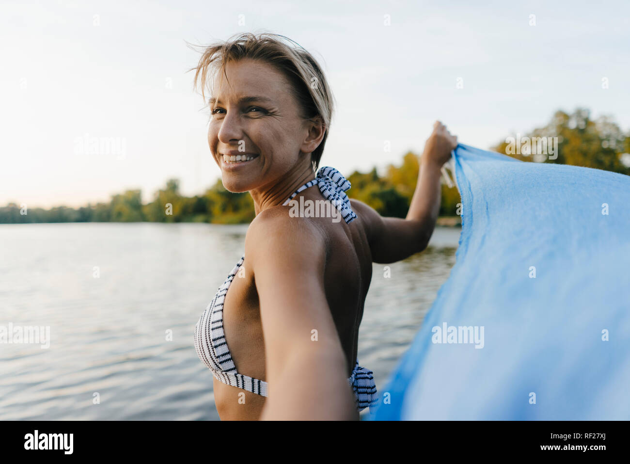 Portrait of happy woman at a lake Stock Photo