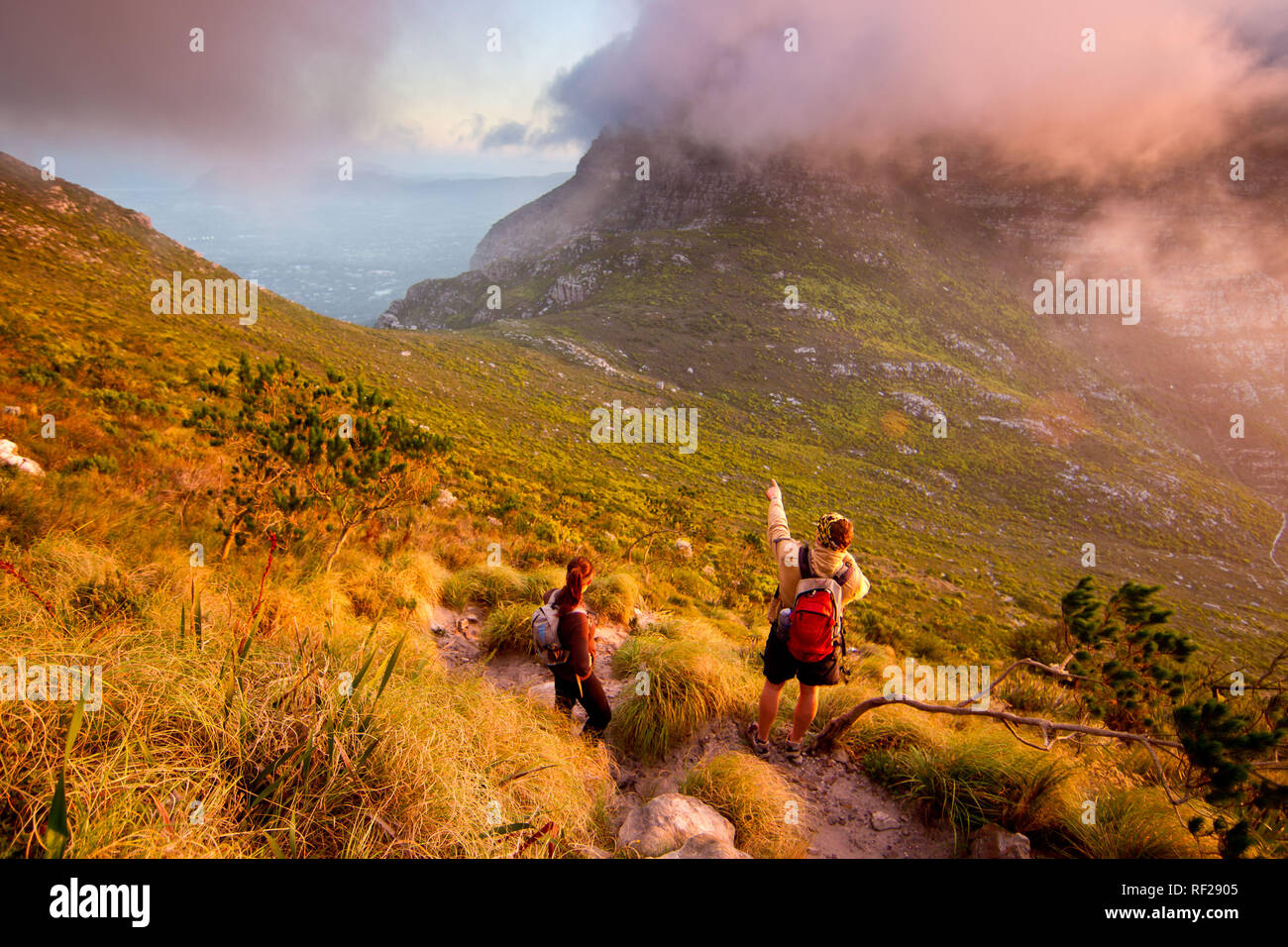 A sunset hike up Devil's Peak afords incredible views as the sun dips below the Atlantic Ocean horizon, Cape Town, Western Cape Province, South Africa Stock Photo