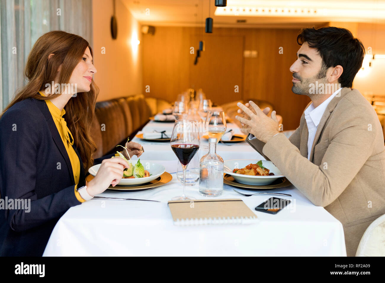 Smiling man and woman eating in a restaurant Stock Photo - Alamy