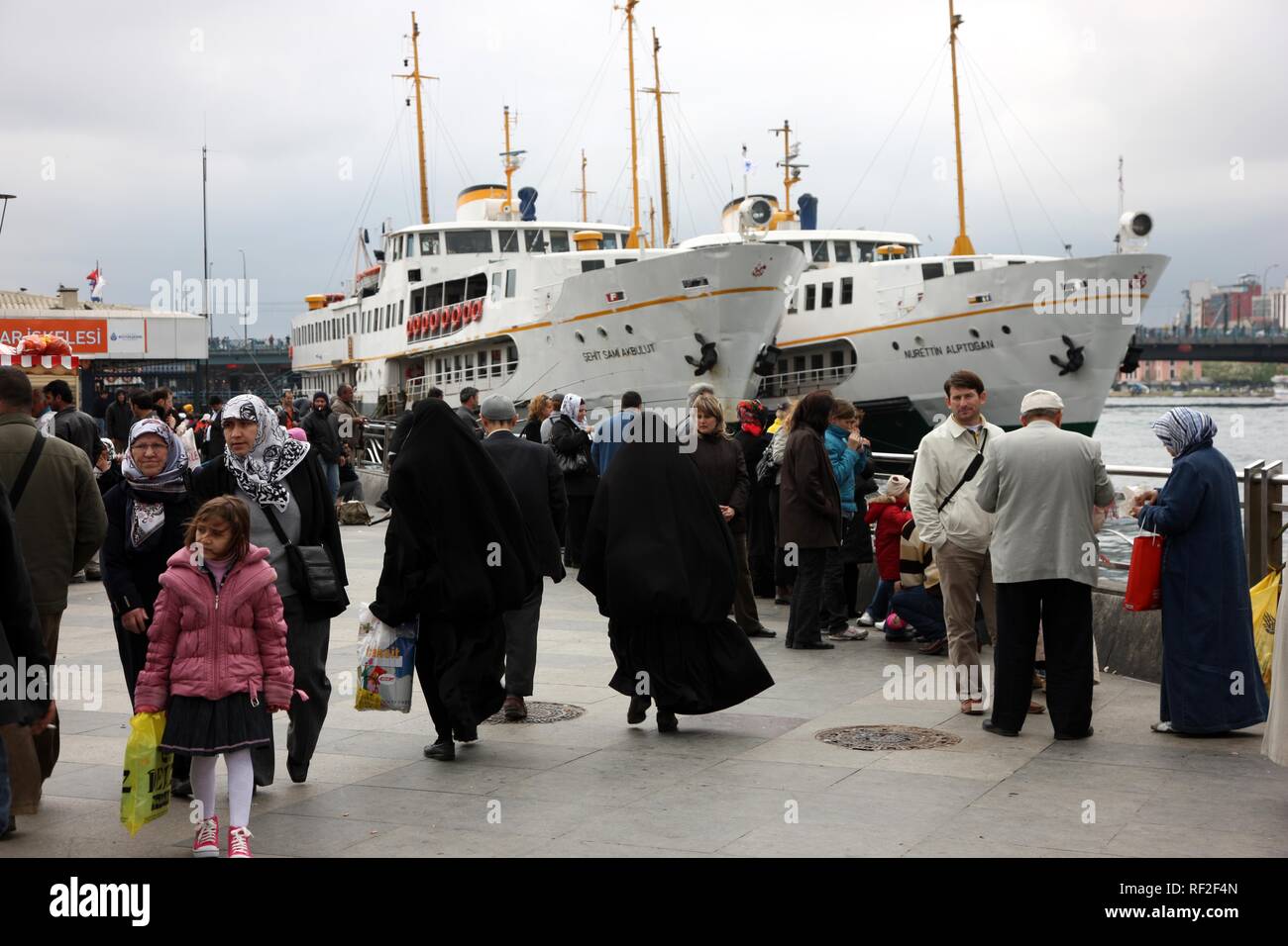 Ferries on the Bosporus, at the harbour of Eminonu, people walking by, Istanbul, Turkey Stock Photo
