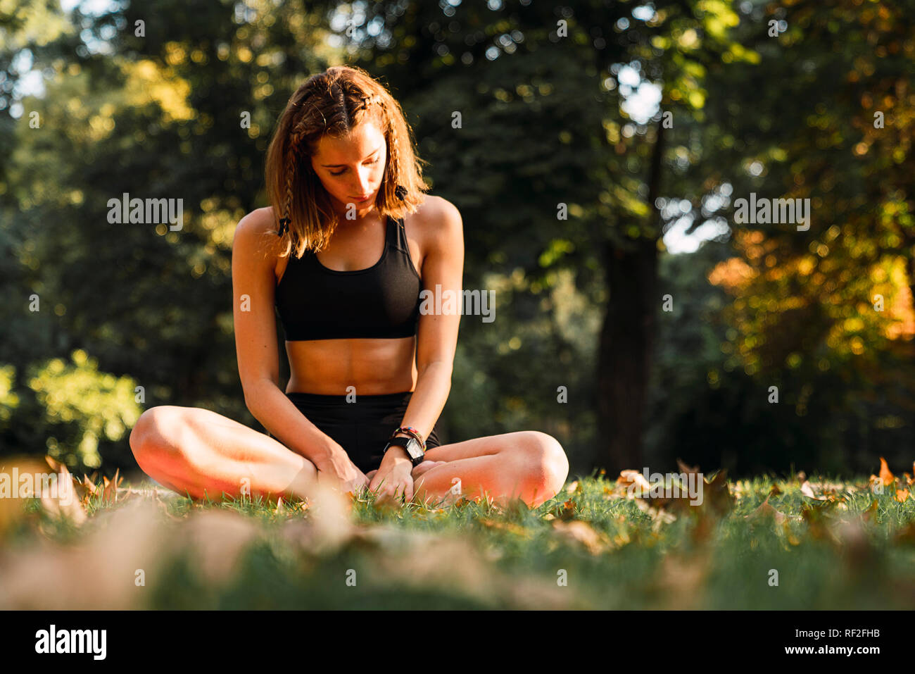 Fit young woman practicing yoga in a park Stock Photo