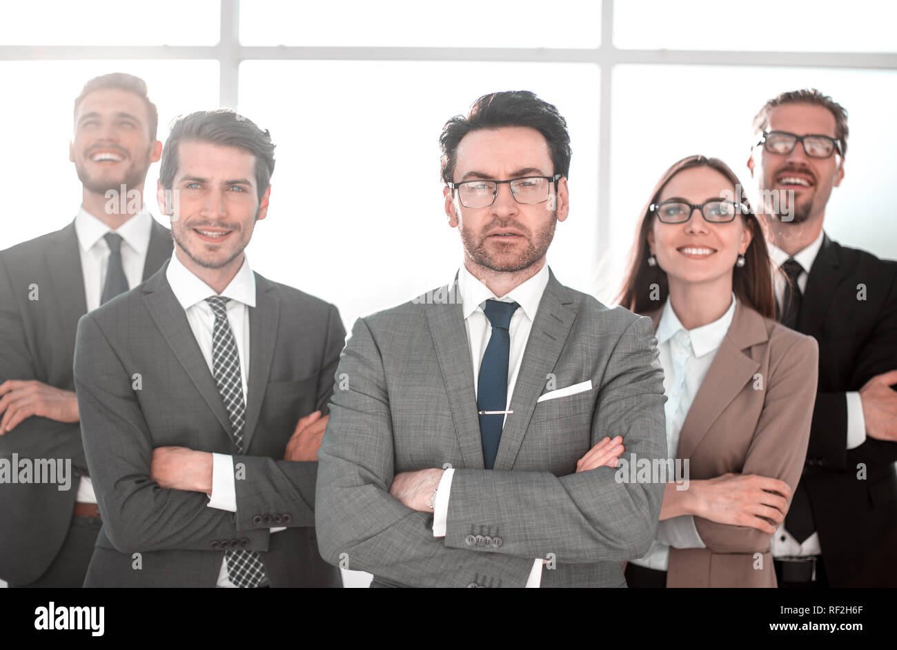 Happy business team with arms crossed at the office Stock Photo - Alamy