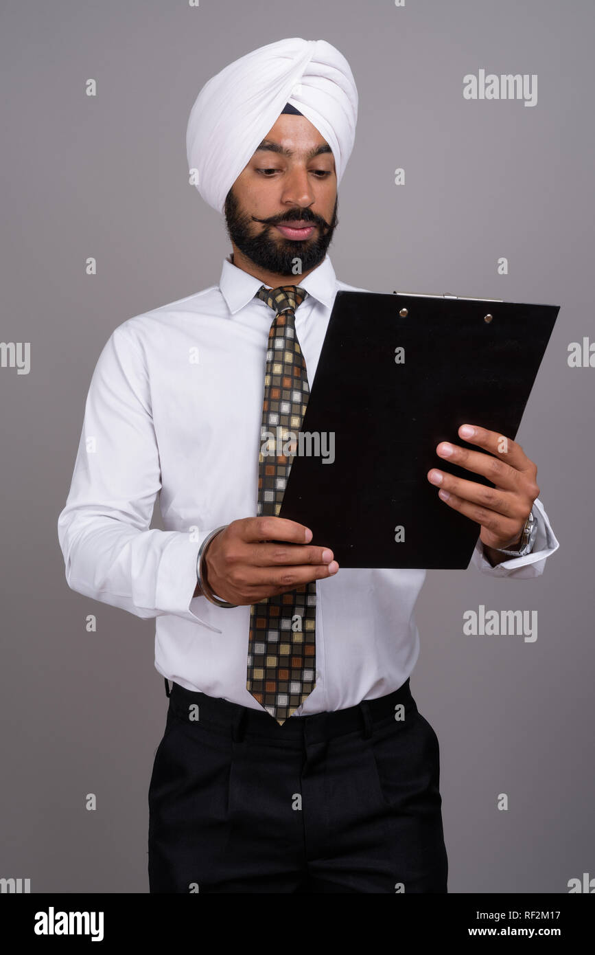 Young handsome Indian Sikh businessman wearing turban against gr Stock  Photo - Alamy